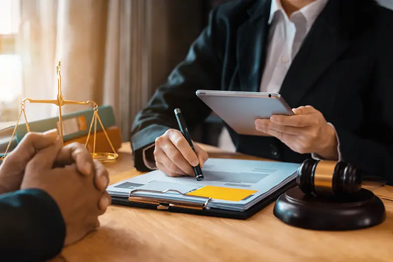 Attorney discussing documents with a client, gavel nearby; Lori Beck Law Office provides personalized consultations in Denver, CO.