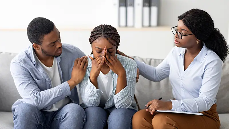 Parents comforting a distressed young woman with a legal professional; Lori Beck Law Office provides comprehensive family legal support in Denver, CO.