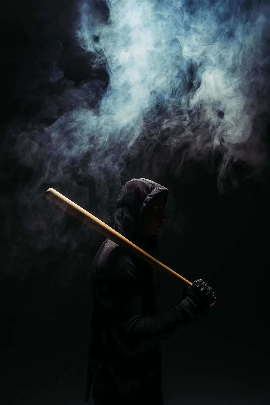 Hooded man holding a baseball bat in smoke, symbolizing violent crime allegations and the need for strong legal defense.