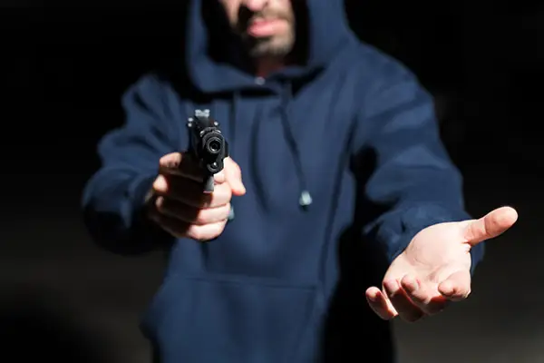 Man pointing a gun during an alleged robbery, symbolizing Colorado robbery charges