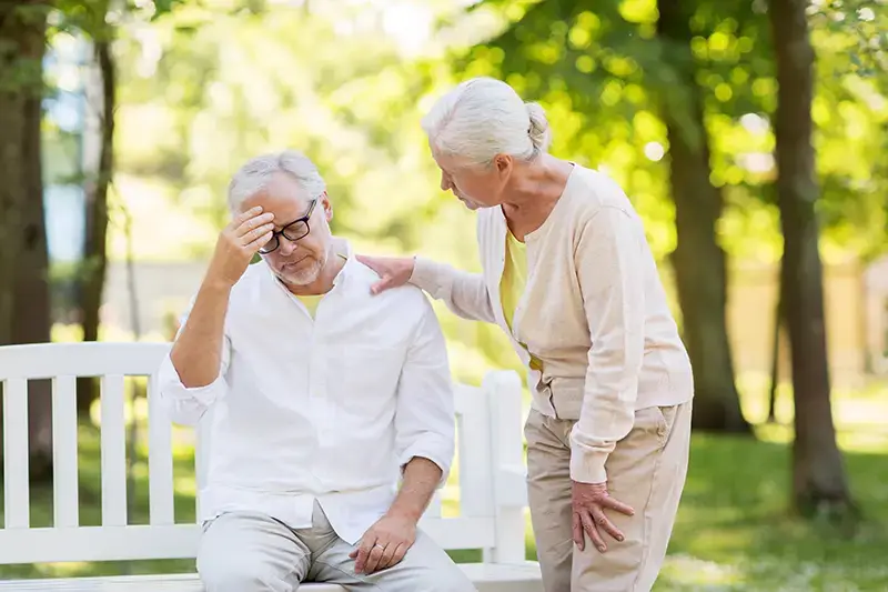 Concerned woman comforting a distressed senior man outdoors; Lori Beck Law Office supports families in Denver, CO.