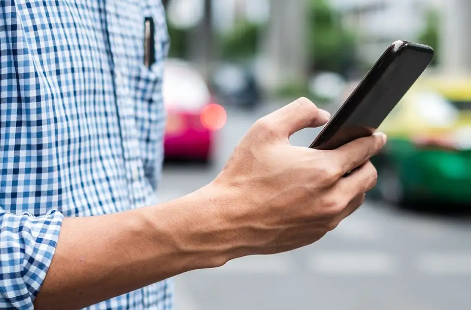 Man using smartphone to order Uber or Lyft rideshare | Denver rideshare injury lawyer