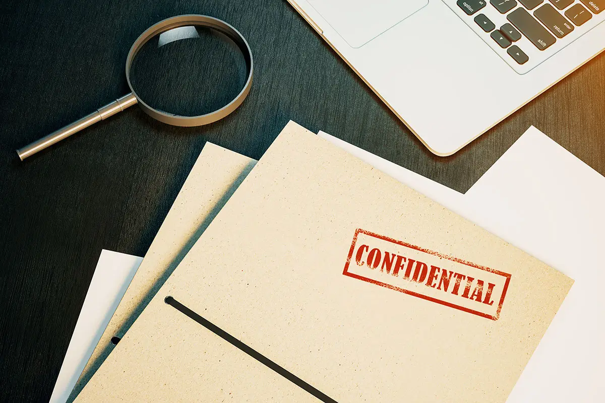 Confidential case file with magnifying glass, symbolizing Colorado criminal record sealing and expungement