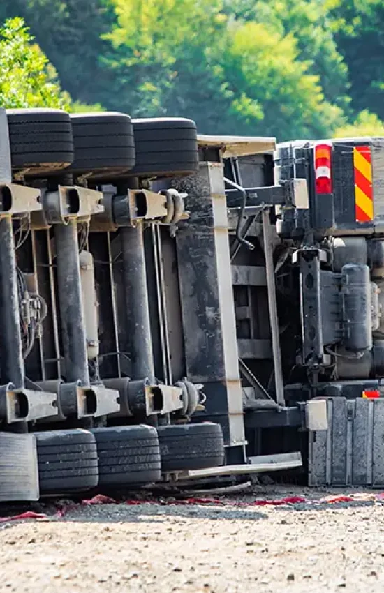 Overturned semi-truck with a distressed man nearby, symbolizing a severe truck accident; Lori Beck Law Office represents victims in Denver, CO.